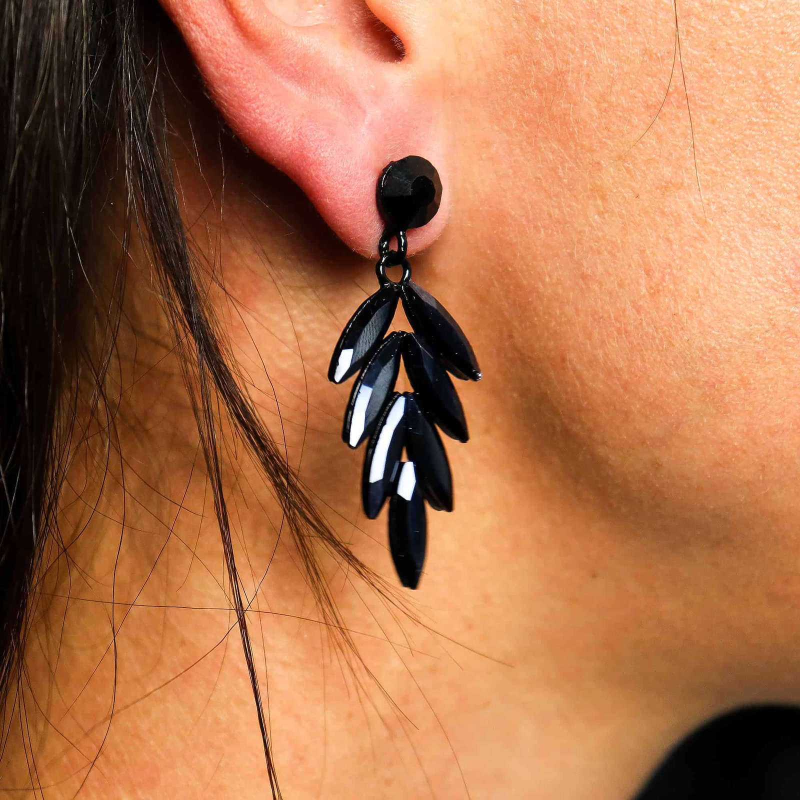 Elegant black dangling leaf-shaped earrings showcased on a woman's ear, highlighting fashionable jewellery accessories for women.