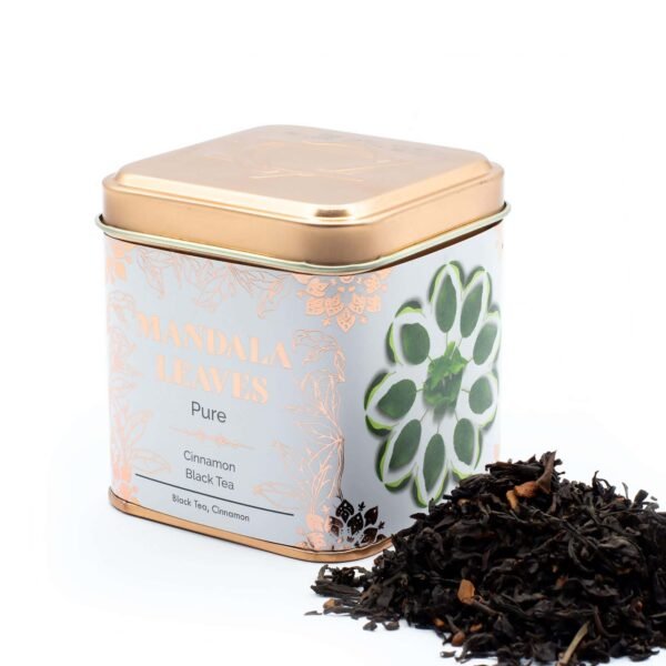 Decorative tin of Mandalas Leaves Pure Black Tea with Cinnamon, featuring a floral design and loose tea leaves beside it, ideal for tea lovers and gift buyers.
