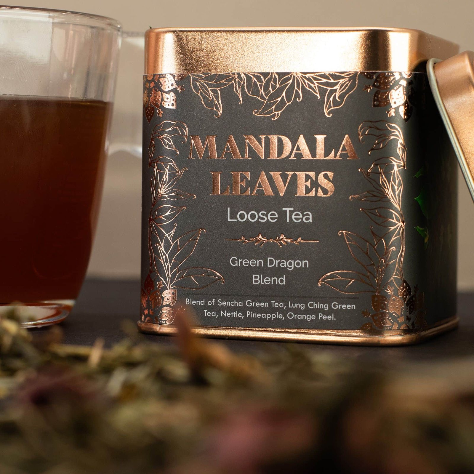 Mandala Leaves loose tea tin featuring a green dragon blend with Sencha green tea, lung ching green tea, pineapple, and orange peel, ideal for tea lovers.