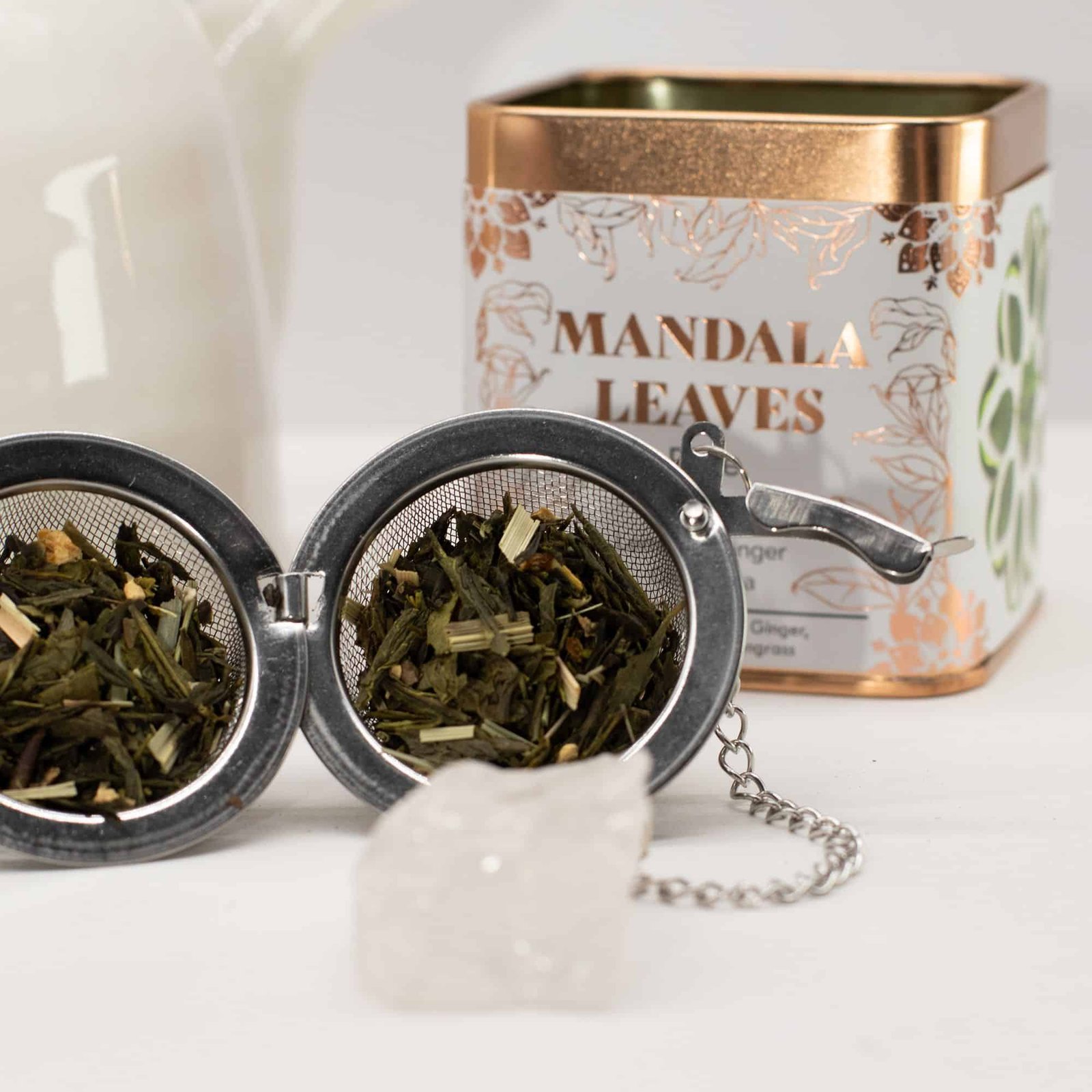 Handcrafted Mandala Leaves herbal tea in a decorative tin with loose tea leaves and a crystal pendant, perfect for gifting or personal relaxation.