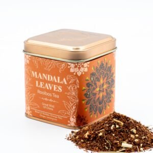 Decorative tin of Mandala Leaves Rooibos Tea with loose tea leaves beside it, showcasing a colourful floral design and natural ingredients, perfect for tea lovers.