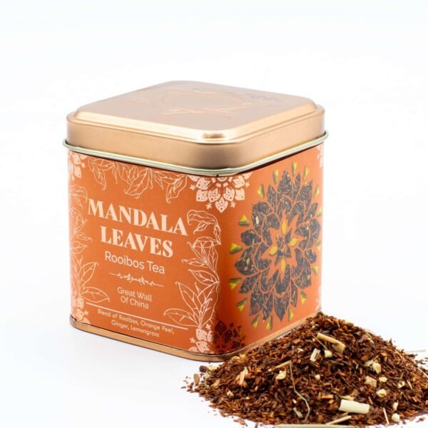 Decorative tin of Mandala Leaves Rooibos Tea with loose tea leaves beside it, showcasing a colourful floral design and natural ingredients, perfect for tea lovers.